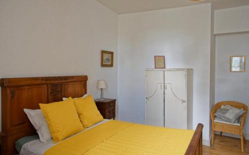 a bedroom with a yellow bed and a white refrigerator at Maison Rives - Village du Livre de Montolieu in Montolieu