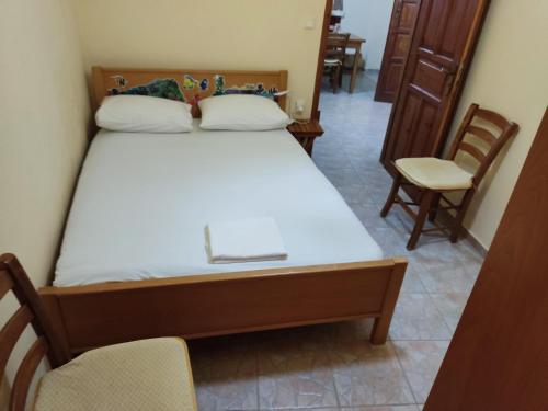 een slaapkamer met een bed en stoelen in een kamer bij Stone House in Triopetra
