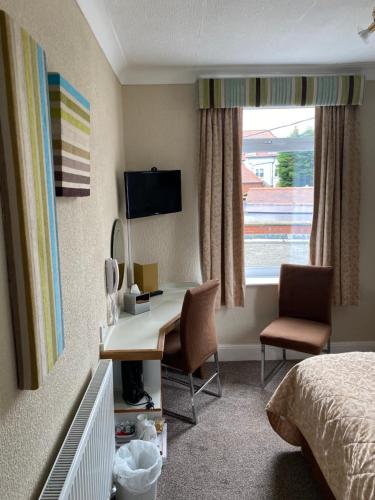 a hotel room with a desk and a bed at Park Manor Hotel in Scarborough