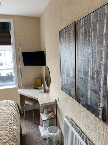a bedroom with a bed and a desk with a mirror at Park Manor Hotel in Scarborough