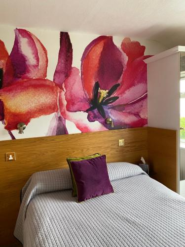 a bedroom with a bed with a flower mural on the wall at Park Manor Hotel in Scarborough