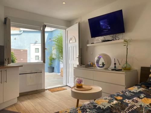 - un salon avec un lit et une télévision murale dans l'établissement Le studio à découvrir., à Marquette-lès-Lille