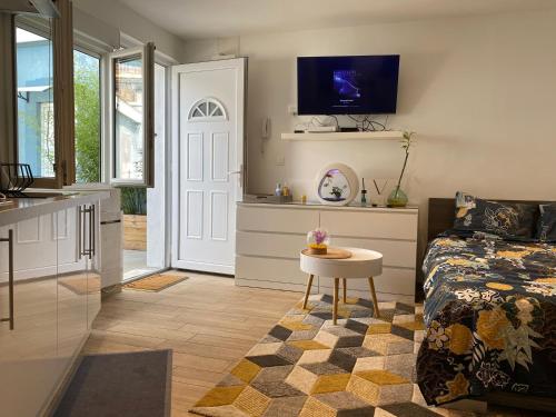 une chambre avec un lit et une table et une cuisine dans l'établissement Le studio à découvrir., à Marquette-lès-Lille