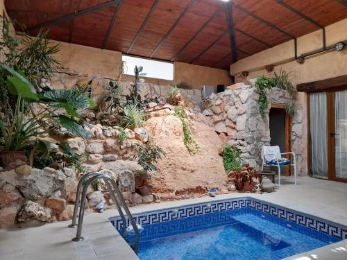 a swimming pool in a house with a stone wall at Casa Blanca in Alhama de Aragón