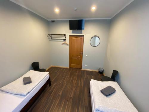 a room with two beds and a door in it at ApartHotel Riga in Rīga