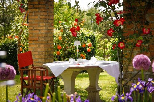a table and chairs in a garden with flowers at All'Antica Scuderia Del Castello in Maiano