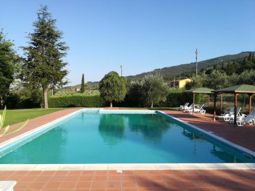 a swimming pool with blue water in a yard at residence San miniato in Loro Ciuffenna