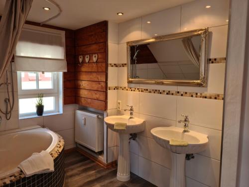 a bathroom with two sinks and a tub and a mirror at Pilgrims "Elli" charmante Maisonette Bad Sassendorf in Bad Sassendorf