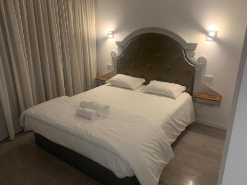 a bedroom with a large bed with white sheets and pillows at O frances in Nelas