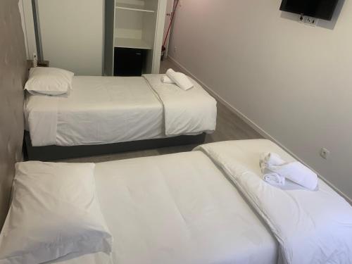 two beds in a hotel room with white sheets at O frances in Nelas