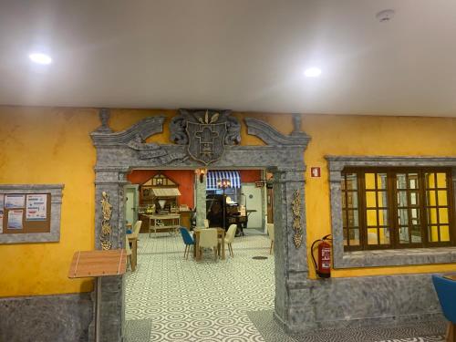 a room with a yellow wall with a table and chairs at O frances in Nelas
