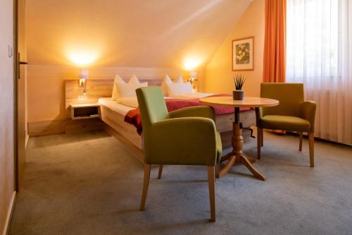 バート・ブランケンブルクにあるHotel Zum Steinhofのベッド、テーブル、椅子が備わるホテルルームです。