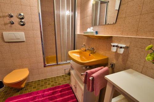 a bathroom with a yellow sink and a toilet at Apartment Anastasia in Garmisch-Partenkirchen