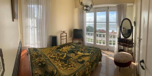 a bedroom with a bed and a mirror and a window at Mar del Plata frente al mar Biblioteca in Mar del Plata