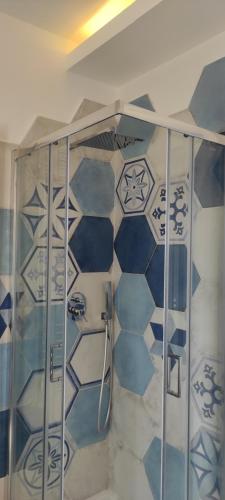 y baño con ducha y azulejos azules y blancos. en Francesco, en Castellabate