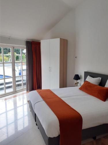 a bedroom with a large bed and a large window at Bed & Breakfast Trouwborst in Rhenen