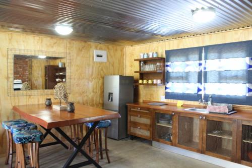 a kitchen with a wooden table and a refrigerator at Casa Cara Resort in Parys