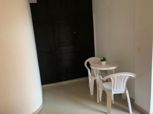 a small table and chairs in a room with a black door at Zaida View in San Andrés