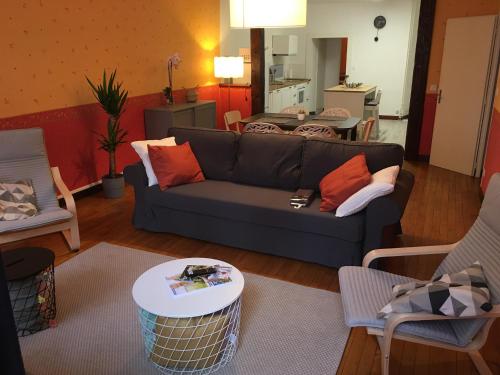 un salon avec un canapé et une table dans l'établissement Grands Gîtes de charme avec jardin, lieu calme et paisible en plein coeur d'Arbois, linge inclu, lits faits à l'arrivée et ménage en fin de séjour, à Arbois