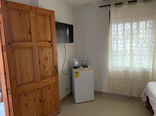 um quarto com um frigorífico e uma porta de madeira em Zaida View em San Andrés