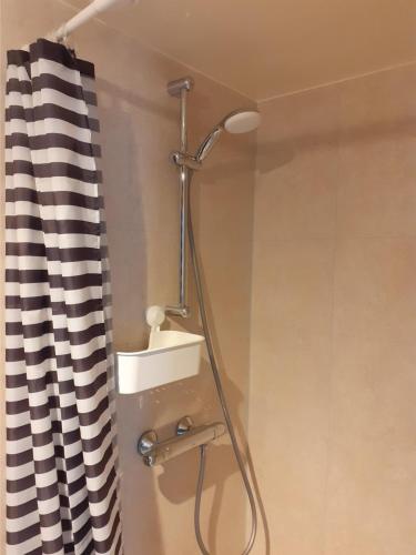 a shower in a bathroom with a black and white shower curtain at Bed & Breakfast Trouwborst in Rhenen