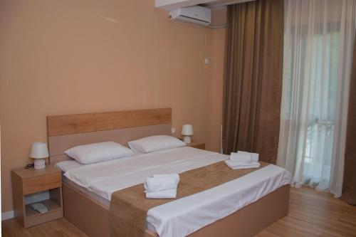 a bedroom with a bed with two towels on it at Likani Home in Borjomi