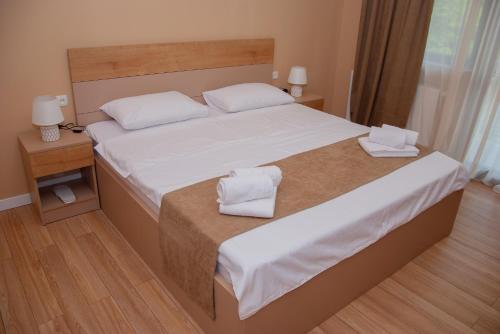 a bedroom with a bed with two towels on it at Likani Home in Borjomi