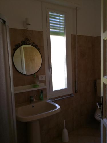 a bathroom with a sink and a mirror and a window at CASA CARBONETTO vicino alla spiaggia in Sanremo
