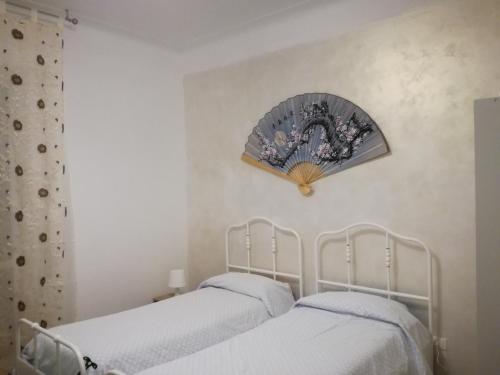 two beds in a bedroom with a mirror on the wall at CASA CARBONETTO vicino alla spiaggia in Sanremo