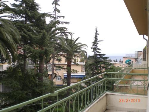 a balcony with palm trees and buildings at CASA CARBONETTO vicino alla spiaggia in Sanremo
