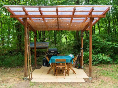 une pergola en bois avec une table et des chaises sous celle-ci dans l'établissement Horizons Verts Luna Tent, à Puivert