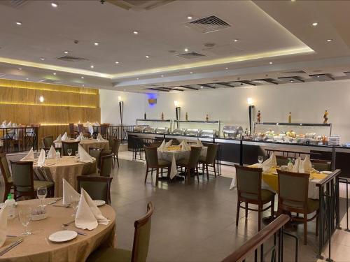 a restaurant with tables and chairs and a bar at Petra Guest House Hotel in Wadi Musa