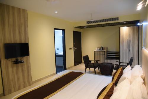 a bedroom with a bed and a television in a room at Broadway Inn in Jaipur