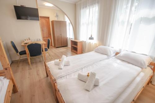 a bedroom with two beds and a table and a room at Olle in Ventspils