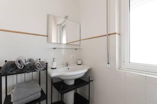 a white bathroom with a sink and a mirror at SEA- ROOM-E in Ladispoli