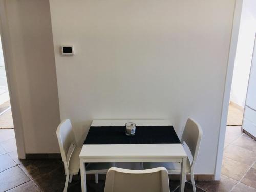 a white table with chairs and a glass on it at SEA- ROOM-E in Ladispoli