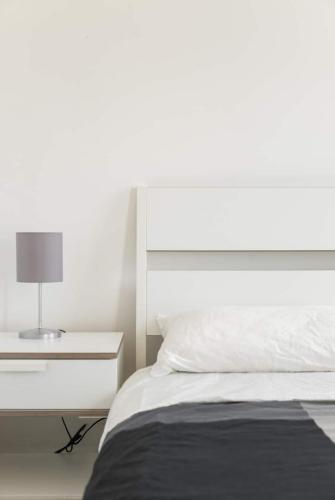 a bedroom with a white bed and a nightstand at SEA- ROOM-E in Ladispoli