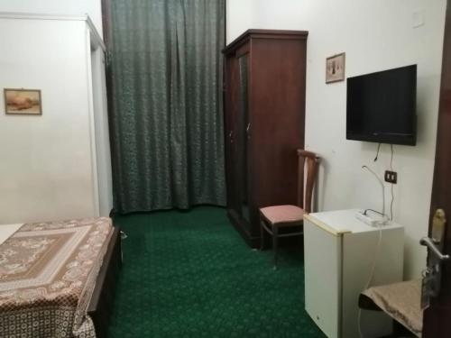 Pokój z łóżkiem, telewizorem i krzesłem w obiekcie Hotel NEW HOTEL w Kairze