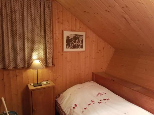 Dormitorio pequeño con cama en el ático en Le Chalet n 0082, en La Thuile
