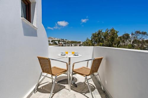 a table and two chairs on a balcony at Ifestos Villa in Fira