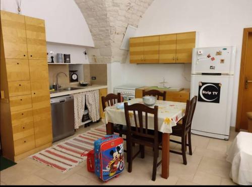 uma cozinha com uma mesa e cadeiras e um frigorífico em Casa Vacanze Giovanni Cesare em Noci
