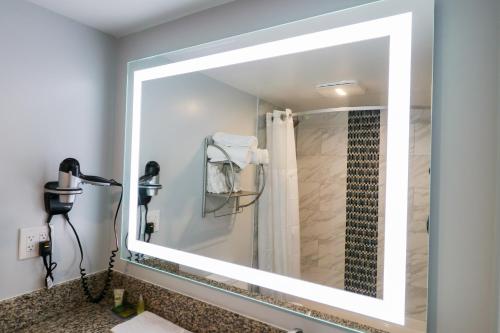 a bathroom with a large mirror over a sink at Envi Boutique Hotel Henderson-Evansville South in Henderson