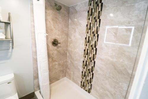 a bathroom with a shower with a glass door at Envi Boutique Hotel Henderson-Evansville South in Henderson