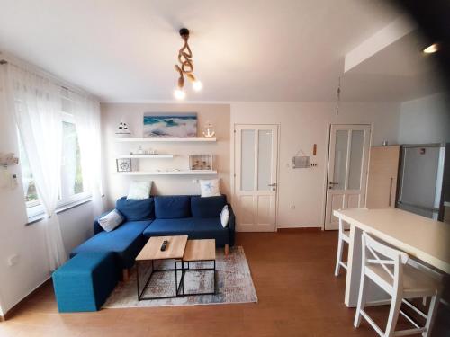 a living room with a blue couch and a table at PALMA TRSAT with free private parking in Rijeka