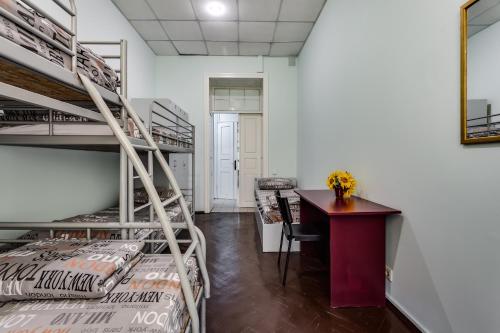 a room with bunk beds and a desk and a table at Mister Hostel in Lviv