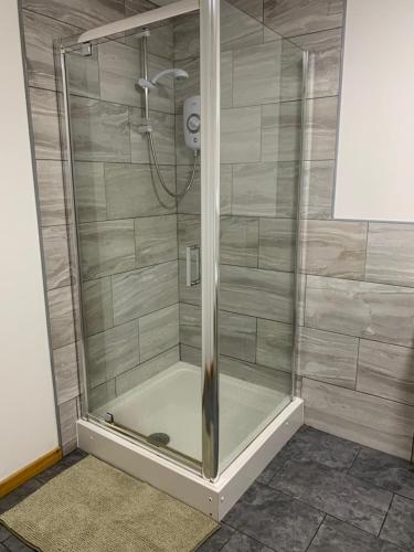 a shower stall with a glass door at GREEN APARTMENTS UNIQUE EXECUTIVE LUXURY in Manchester