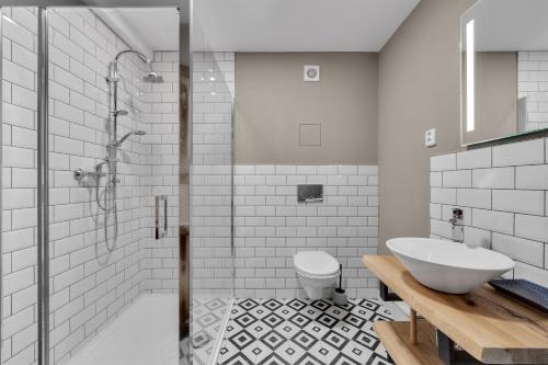 a bathroom with a shower and a toilet and a sink at Joy Aparthotel Keilberg in Klínovec