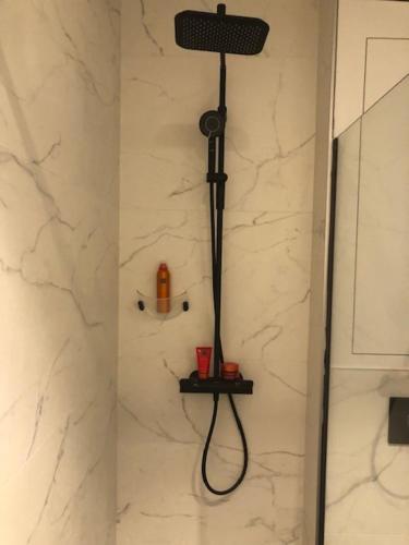 een douche met een zwarte slang in de badkamer bij bloc79/zero in Knokke-Heist