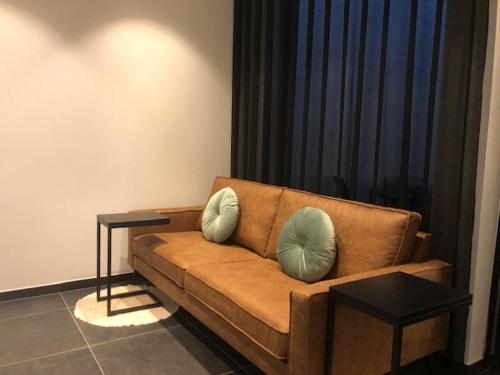 a living room with a brown couch and two tables at bloc79/zero in Knokke-Heist