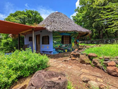 uma pequena casa com telhado de palha em Finca del Sol Eco Lodge em Santa Cruz